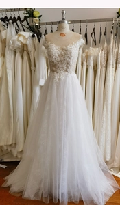 Detailed view of white lace floral embroidery and beadwork on a bridal gown bodice