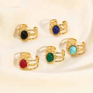 Details of five vintage adjustable rings with oval stones on beige silk fabric