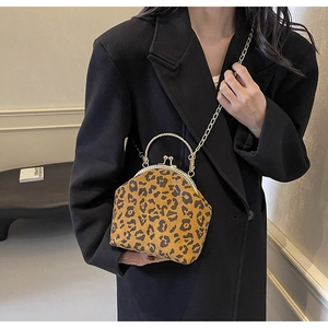 Detailed macro view of the leopard print shell bag featuring a gold metal handle and chain