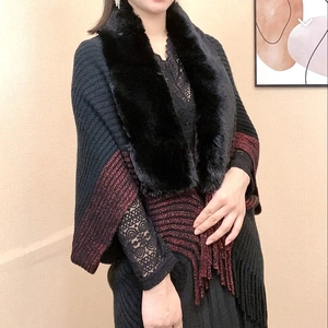 Detail of knit shawl featuring faux fur collar, red-black stripes with glitter and tassels