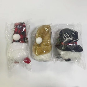 Three Christmas gnome plush dolls in red plaid, brown and black with white beards in packaging