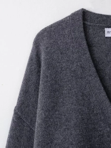 Vue macro détaillée de la texture du tricot en laine gris foncé et du col en V de qualité