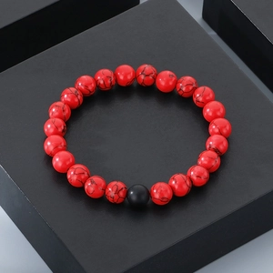 Detailed close-up of red stone beaded bracelet with 8mm beads and single black accent bead