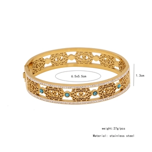 Detail view of hollowed stainless steel cuff bracelet with turquoise and clear crystals
