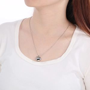 Close-up of a silver 3D heart pendant necklace on a model for a minimalist summer jewelry look