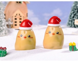 Mini Christmas potato figurines with red hats in a snowy micro landscape scene