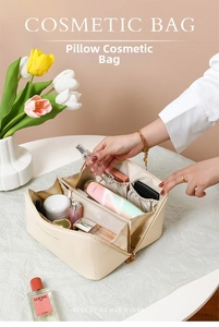 Detail view of large capacity cream cosmetic bag with interior elastic pockets and wide opening