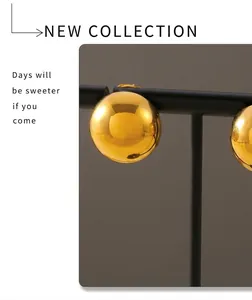 Detailed view of polished gold semi-round stud earring on a black minimalist display stand