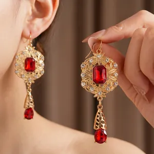 Vintage gold drop earrings featuring large red gemstones and shimmering zircon accents