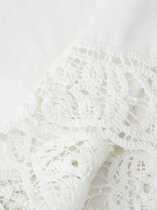 Vue macro de la bordure en dentelle crochetée sur un tissu de chemisier blanc