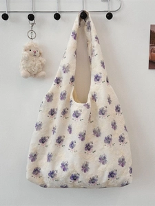 Minimalist canvas tote bag with purple floral embroidery and cute sheep charm on white wall
