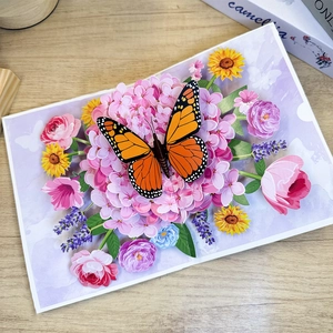 3D pop-up card featuring a monarch butterfly on pink hydrangeas and colorful floral bouquet