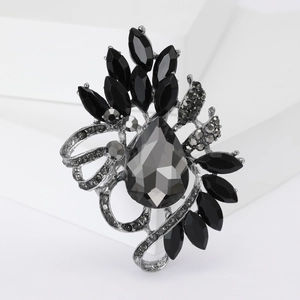 Detailed close-up of a vintage crystal brooch with grey teardrop and black marquise gems