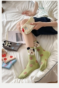 Detailed view of mid-calf cotton socks with cute cartoon animal patterns and polka dots