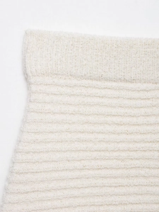 Détail de la maille blanc cassé et taille côtelée sur cet ensemble chic à franges