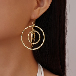Detailed close-up of golden hollow multi-layered round hoop earrings on a model
