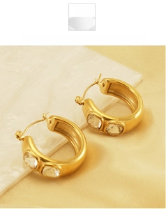 Close-up of 18K gold plated C-shaped hoop earrings featuring two round zircon stones