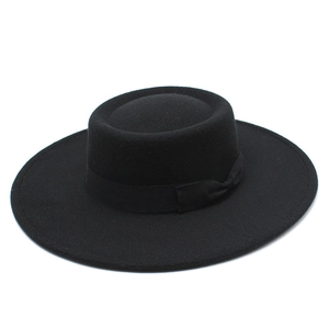 Detail of classic black wool felt flat top boater hat with silk ribbon bow decoration