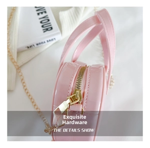 Close-up of pink jelly mini bag featuring polished gold metal zipper and chain details