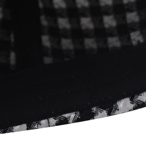 Macro shot of houndstooth pattern fabric and reinforced stitching on baseball cap