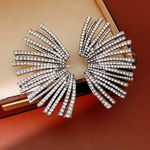 Detailed view of fan-shaped rhinestone earrings resting in a premium jewelry box