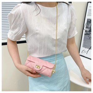 Pink quilted cylinder bag detail featuring gold chain strap and pearl decorative accents