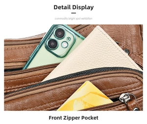 Detail view of the brown leather crossbody bag showing functional front zipper pocket storage