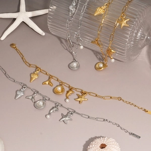 Gold and silver stainless steel ocean bracelets with shell, starfish, and pearl charms