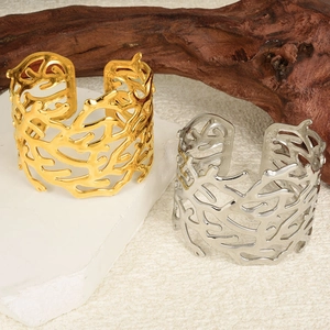 Detailed macro view of gold and silver C-shaped open bracelets with organic coral texture
