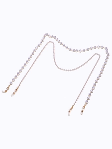 Detail of double-layered pearl eyewear chain with golden lobster clasps and rubber loops