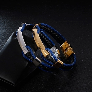 Détail de bracelets en cuir tressé avec fermoir poli en acier inoxydable et cordons bicolores