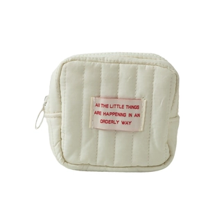 Minimalistische cremefarbene gesteppte Kosmetiktasche mit weichem Stoff-Etikett