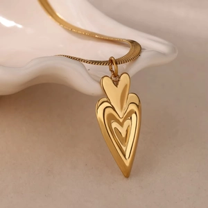 Collana a doppio strato in titanio con ciondoli a cuore dorati a più livelli