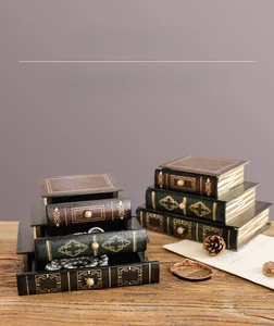 Detail view of vintage book-shaped jewelry box with three drawers and gold floral patterns