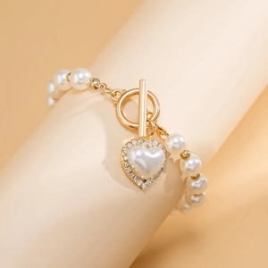 Detailed view of heart pearl pendant with gold plating and sparkling rhinestones