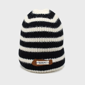 Close-up of thick knit striped beanie featuring the ADER leather patch and ribbed cuff