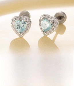 Macro detail of heart-shaped blue zircon earrings with titanium steel screw back studs