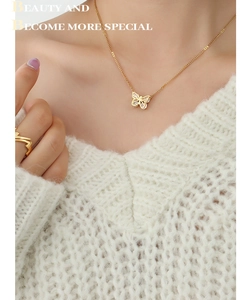 Detail of 18K gold-plated butterfly necklace with zircons worn on model collarbone