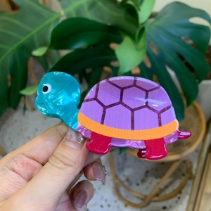 Detailed view of handmade colorful turtle hair claw clip with pearlescent acetate finish