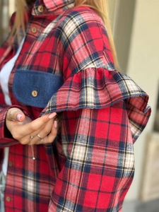 Détail de la manche d'une chemise à carreaux rouges avec volants et poche en jean bleu