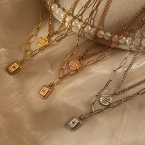 Detail of layered gold and silver starburst pendant necklaces on silk background