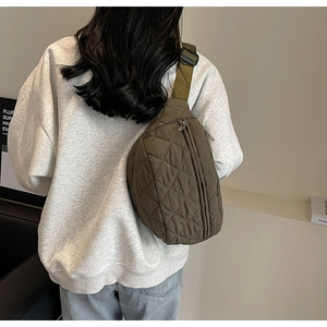 Army green quilted crossbody chest bag shown on model with adjustable strap detail