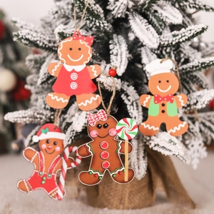 Set of 4 Christmas wooden gingerbread man ornaments hanging on a snowy tree