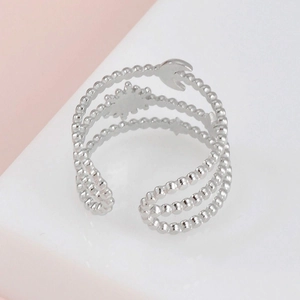 Detail of silver multi-layer beaded ring with moon and star charms and open band