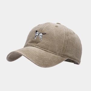 Close-up of vintage washed khaki cotton cap featuring detailed dog embroidery and texture