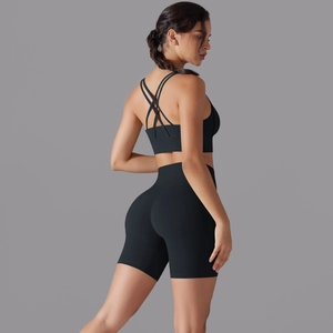 Dettaglio del reggiseno sportivo incrociato e pantaloncini yoga a vita alta neri