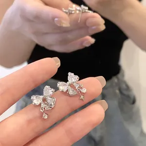 Boucles d'oreilles nœud asymétriques avec zircons et pendentifs étoile et rond