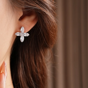 Gros plan d'une boucle d'oreille à quatre pétales en zircon avec pierres marquises sur le mannequin