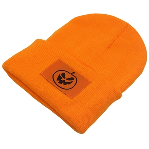 Close-up of the orange knit beanie with a square patch featuring a pumpkin face embroidery