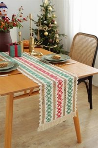 Detailed texture of Christmas cotton linen table runner with red green woven tassels
